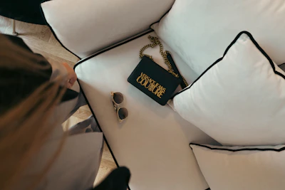 A stylish designer handbag placed on a marble countertop with gold accents catching the light