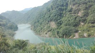 A serene view of the Ganges river flowing gently through lush green valleys
