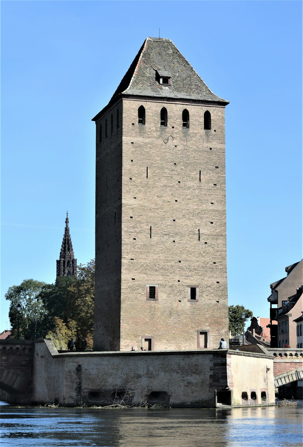 a tall brick tower sitting on top of a river