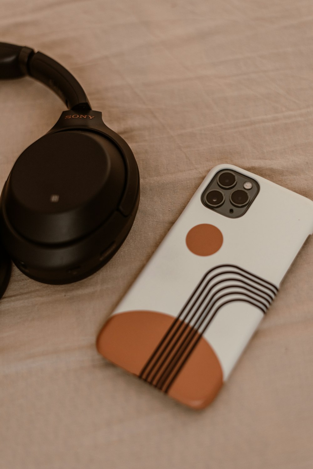 a pair of headphones sitting next to a phone case