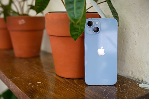 a blue iphone sitting on top of a wooden table