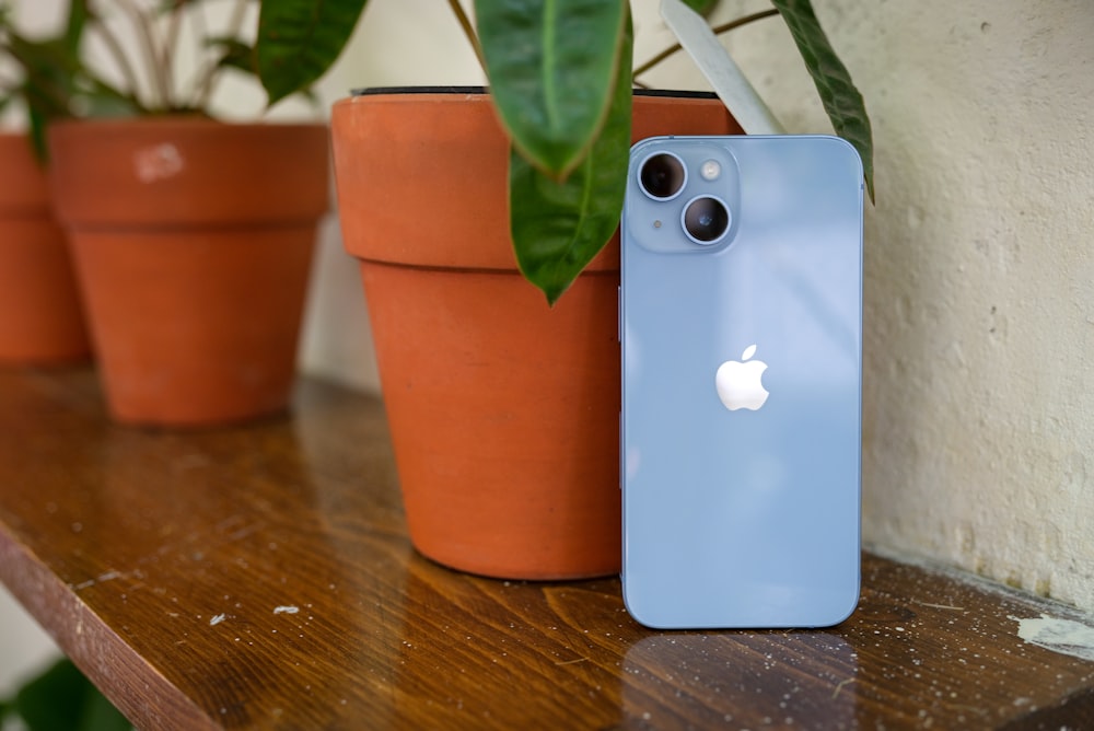 Un iPhone blu seduto sopra un tavolo di legno