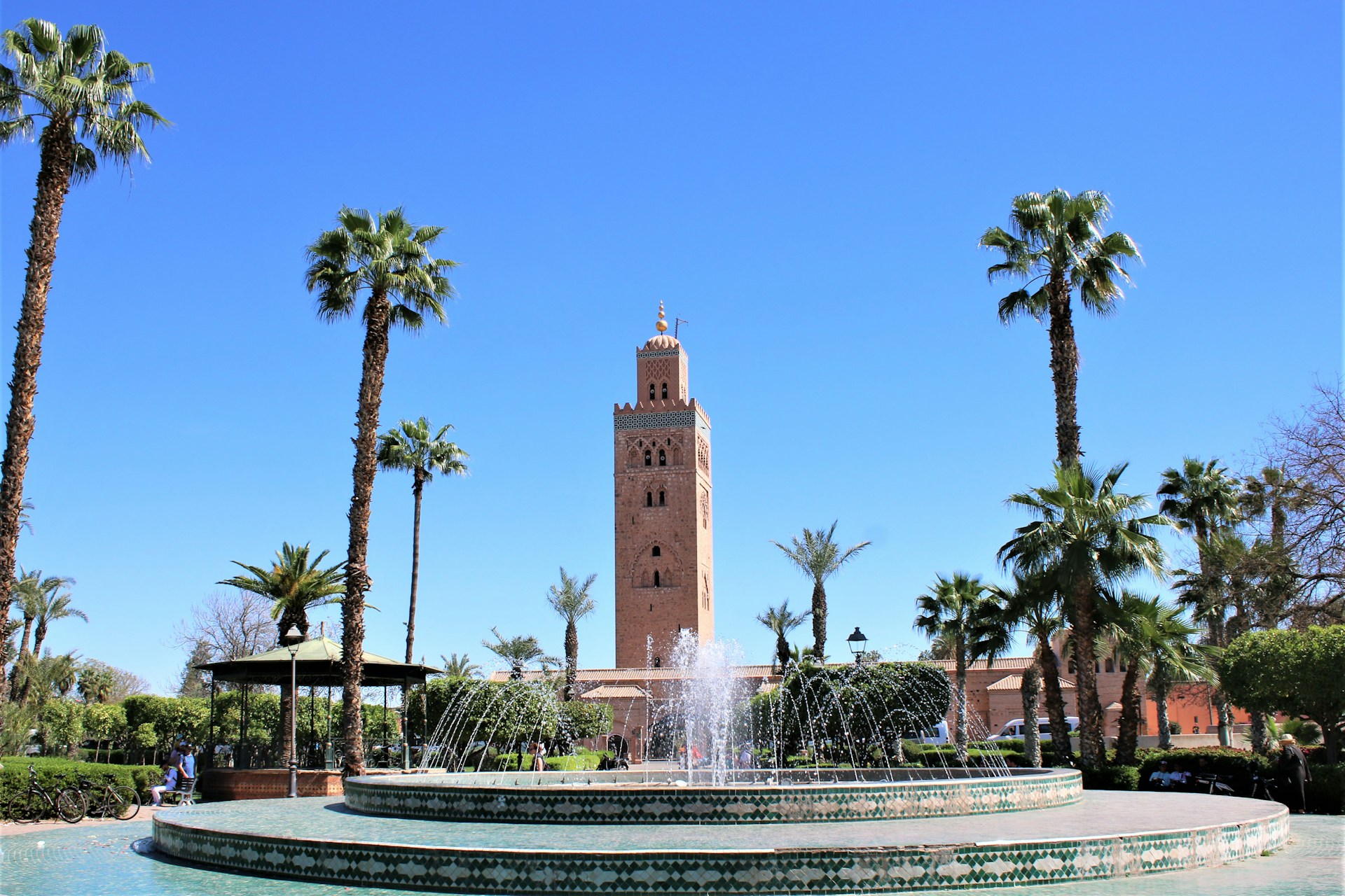 a fountain with a clock tower in the background