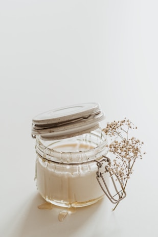 Glass jars filled with fresh milk and cream.