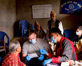 A friendly agent warmly assisting a senior couple with Medicare paperwork in a cozy office.