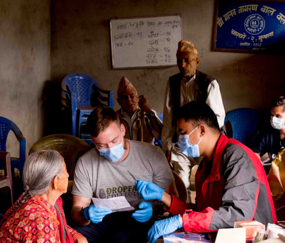 A friendly agent warmly assisting a senior couple with Medicare paperwork in a cozy office.