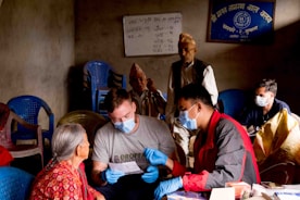 A caring volunteer assisting an elderly woman with paperwork in a cozy home setting.
