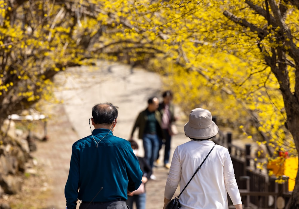 a man and a woman walking down a tree lined path