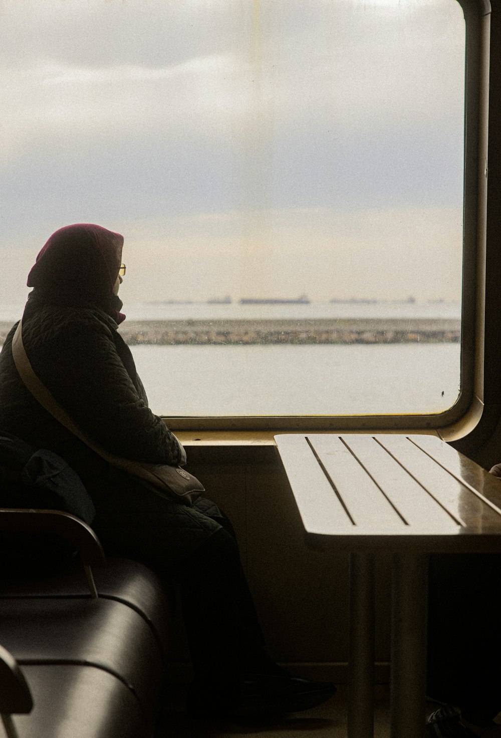 a woman sitting on a train looking out the window