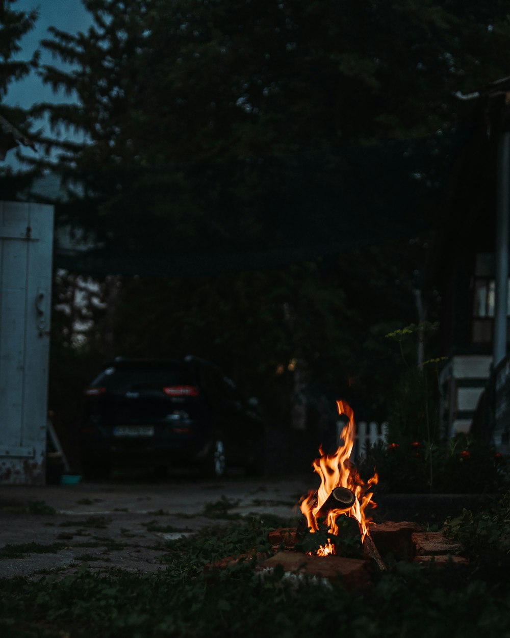 a fire burning in a yard next to a house