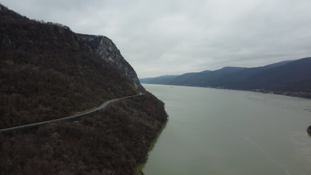 an aerial view of a winding road near a body of water