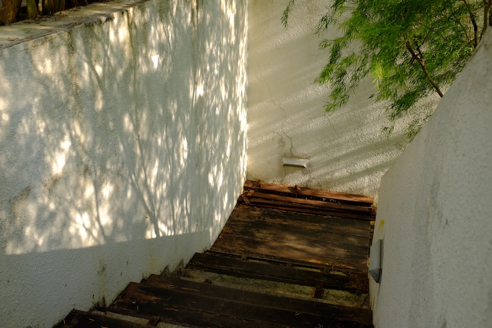 a wooden staircase leading up to a white wall