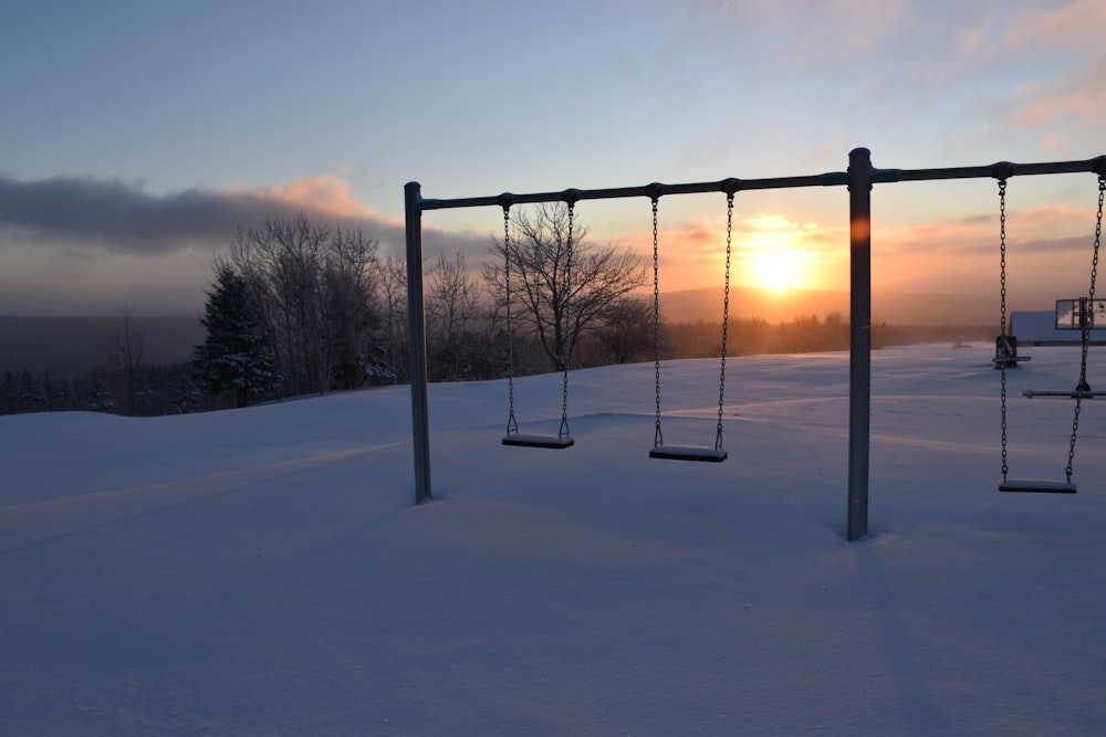 a couple of swings that are in the snow