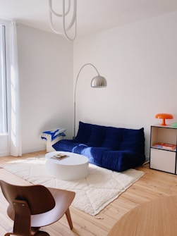 a living room with a blue couch and a white rug