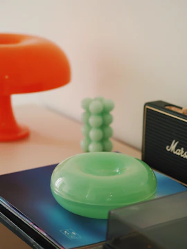 A vibrant orange smart home gadget glowing on a sleek modern table