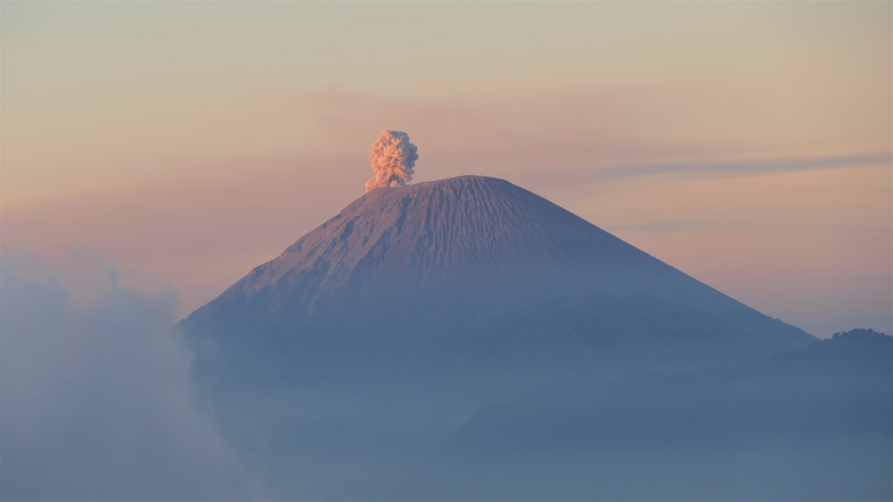 a large mountain with a plume of smoke coming out of it