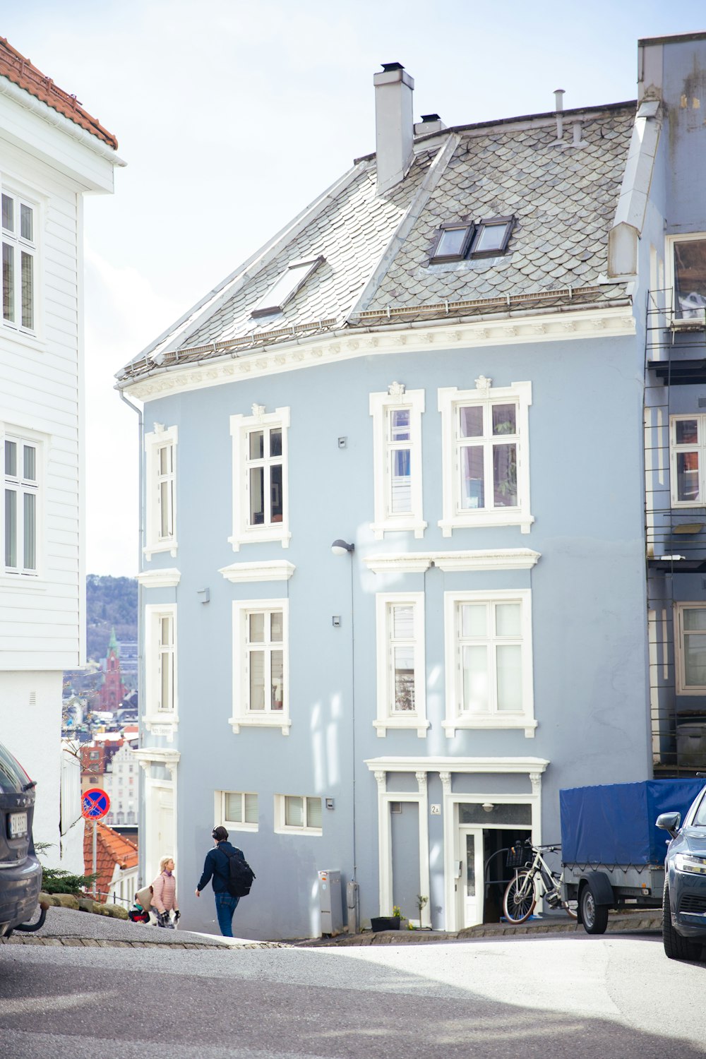 a person walking down a street in front of a blue building