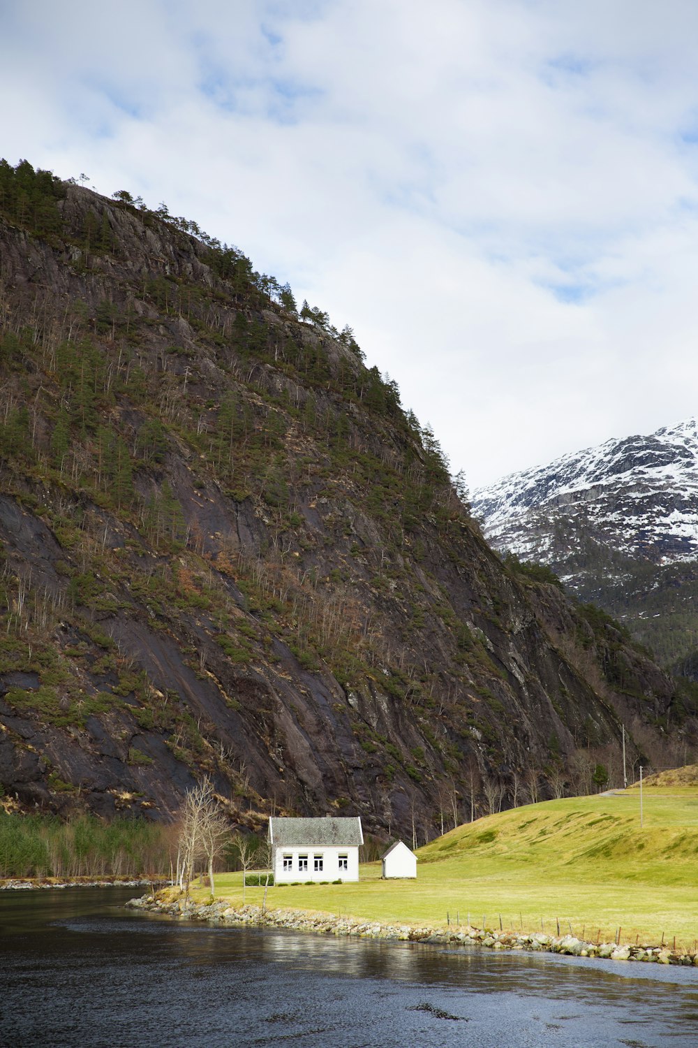 a small white house sitting on the side of a mountain