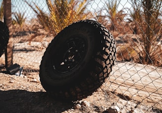 a tire on the ground next to a fence