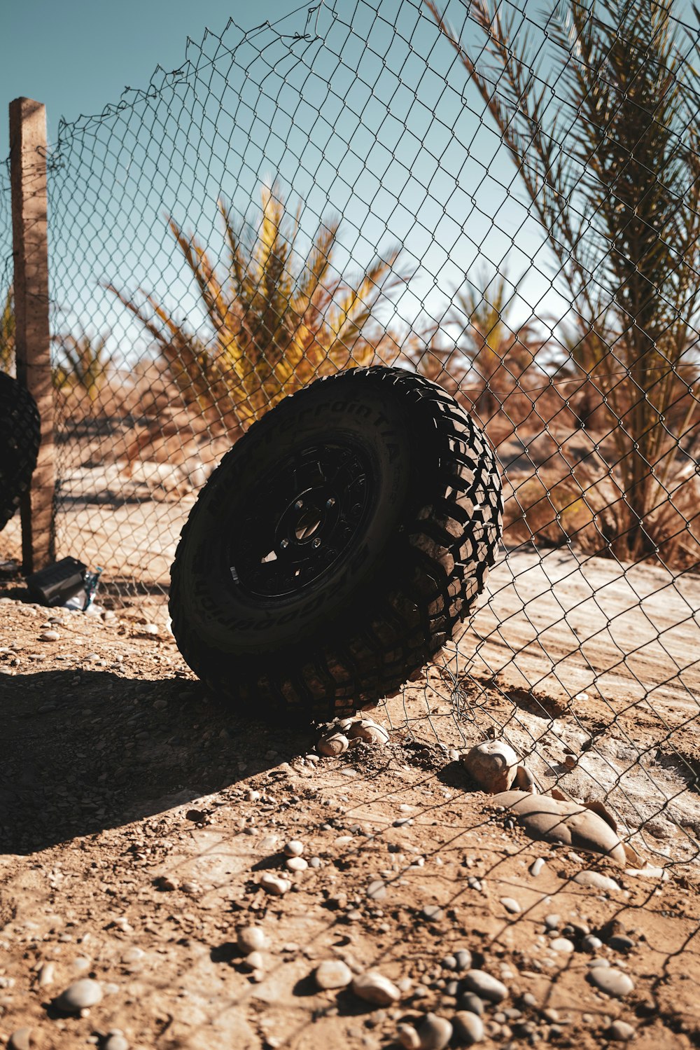 a tire on the ground next to a fence