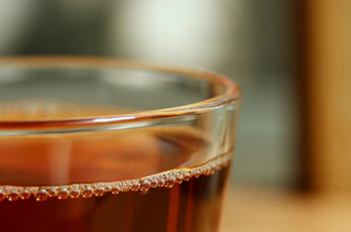 Un acercamiento al borde de un vaso de kombucha.