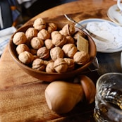 a bowl of walnuts on a wooden table