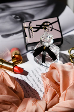 A chic flat lay of xo éclat's signature red, black, and gold accessories and skincare products on a sleek black surface.