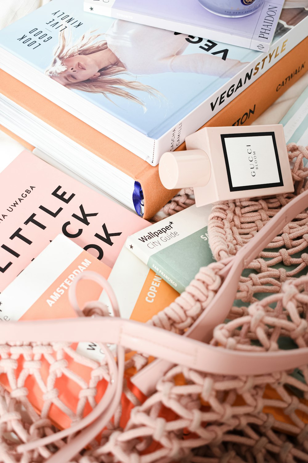 a pile of books sitting on top of a pink blanket