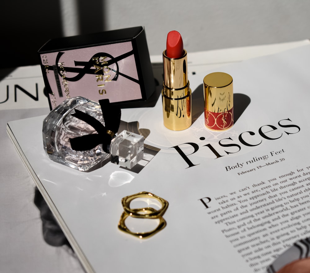 a magazine with a ring, lipstick, and other items