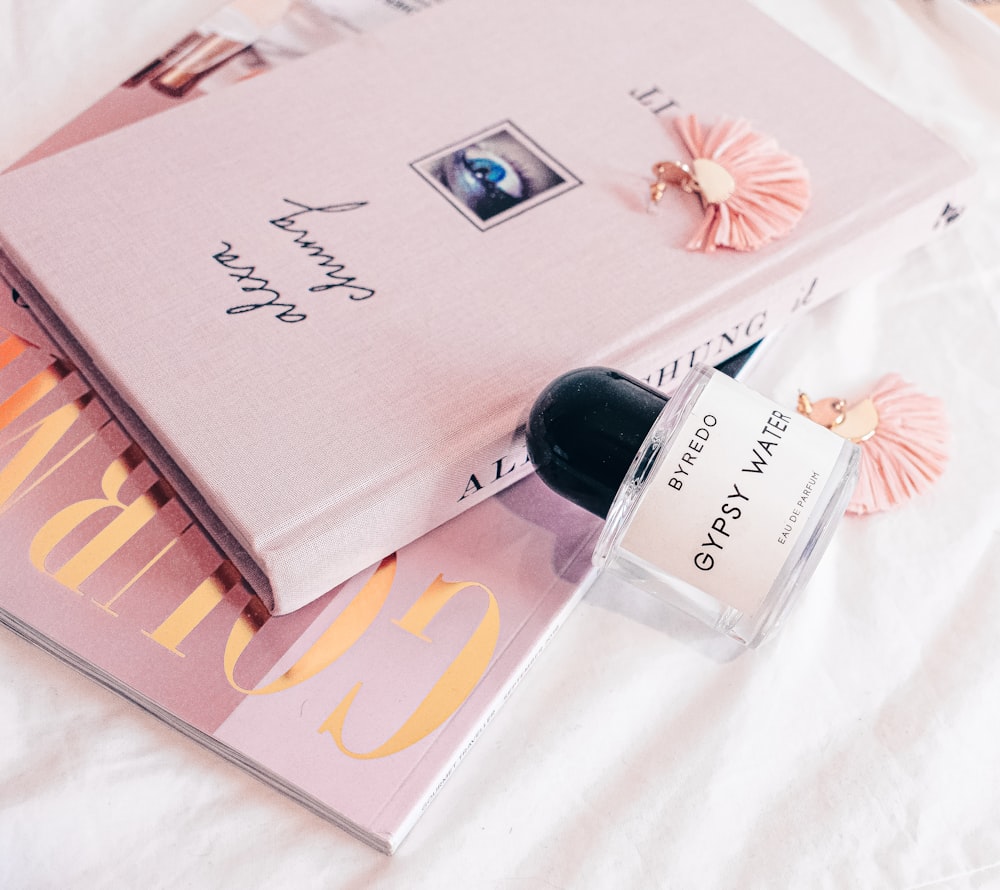 a bottle of perfume sitting on top of a book
