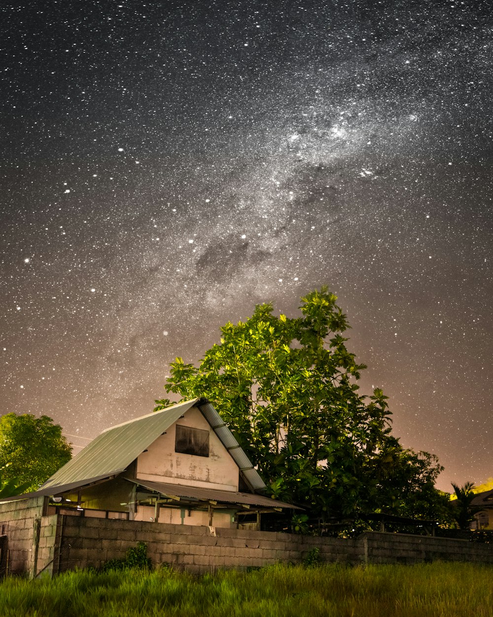 the night sky is filled with stars above a house