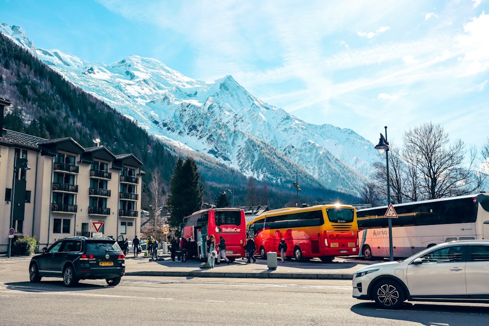 a group of buses parked next to each other in front of a mountain