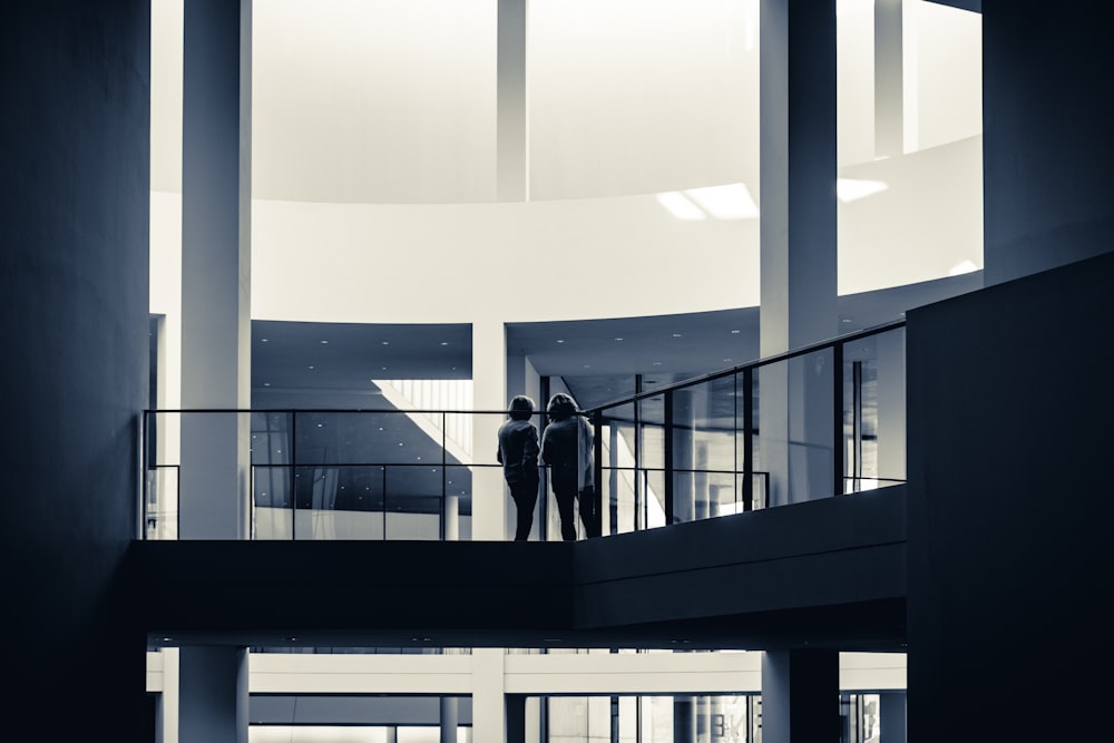 two people standing on a balcony in a building