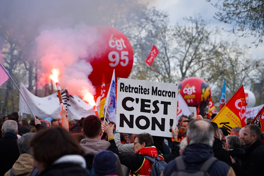 a crowd of people holding signs and flarers