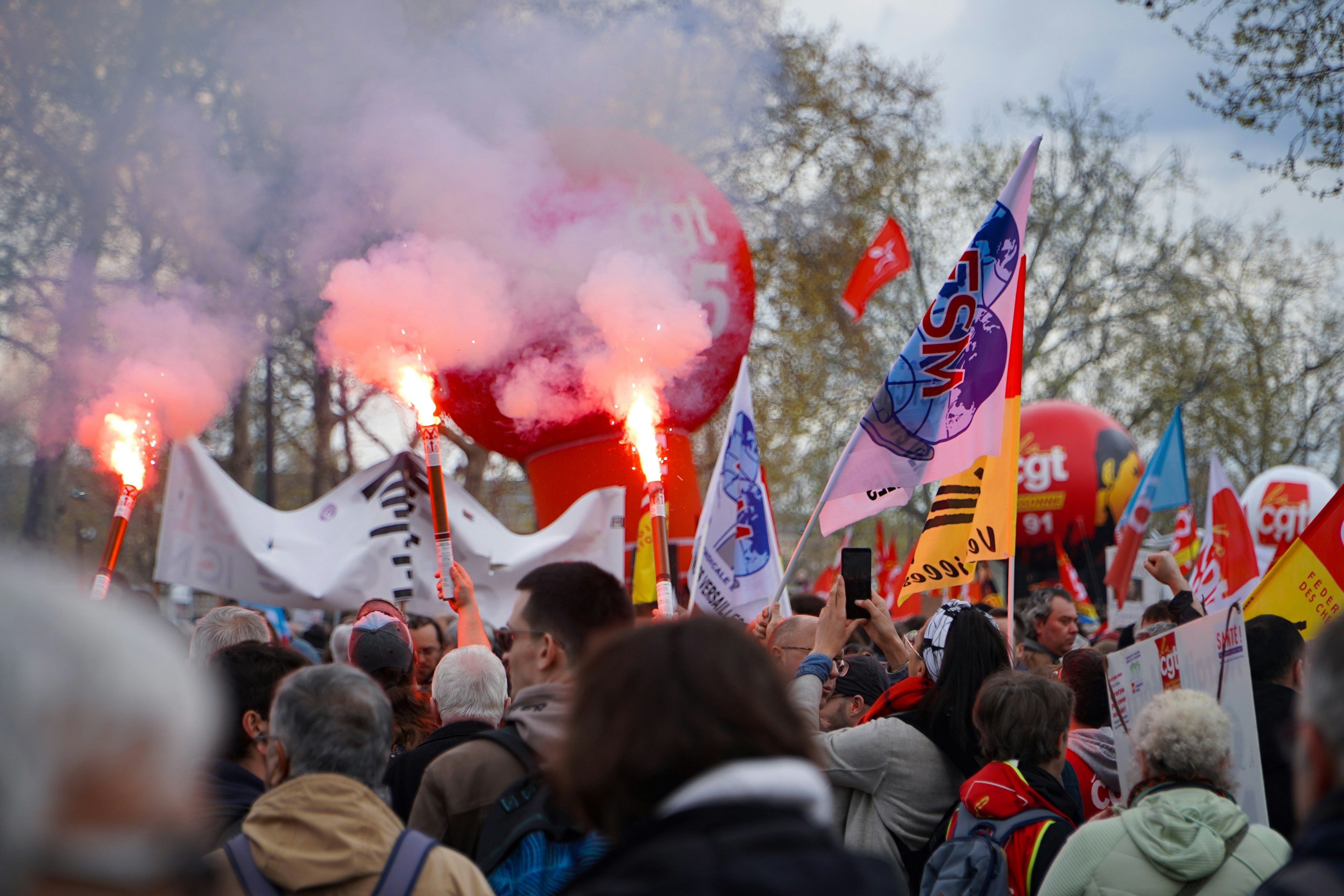 Una multitud de personas sosteniendo banderas y bengalas
