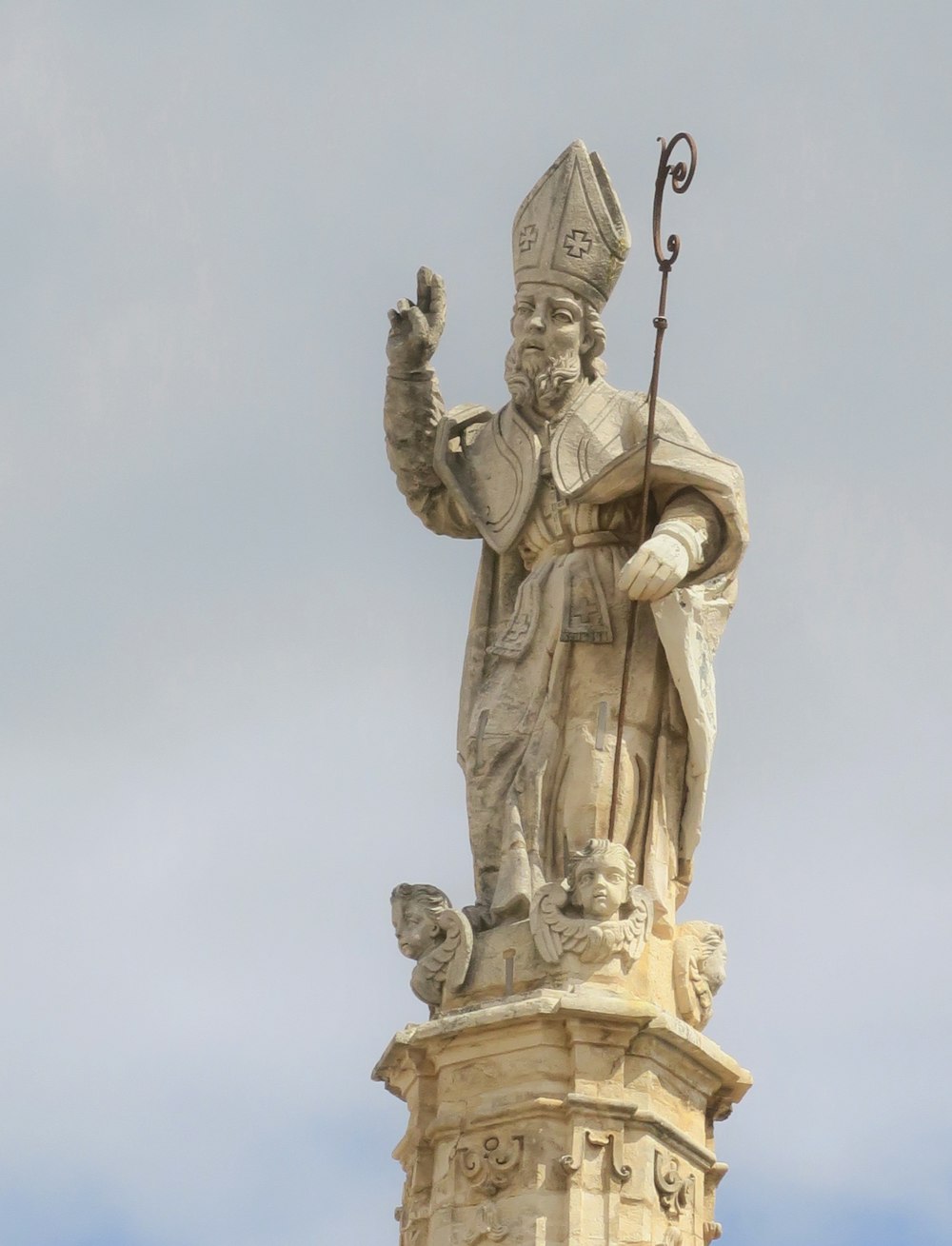 a statue of a man holding a staff