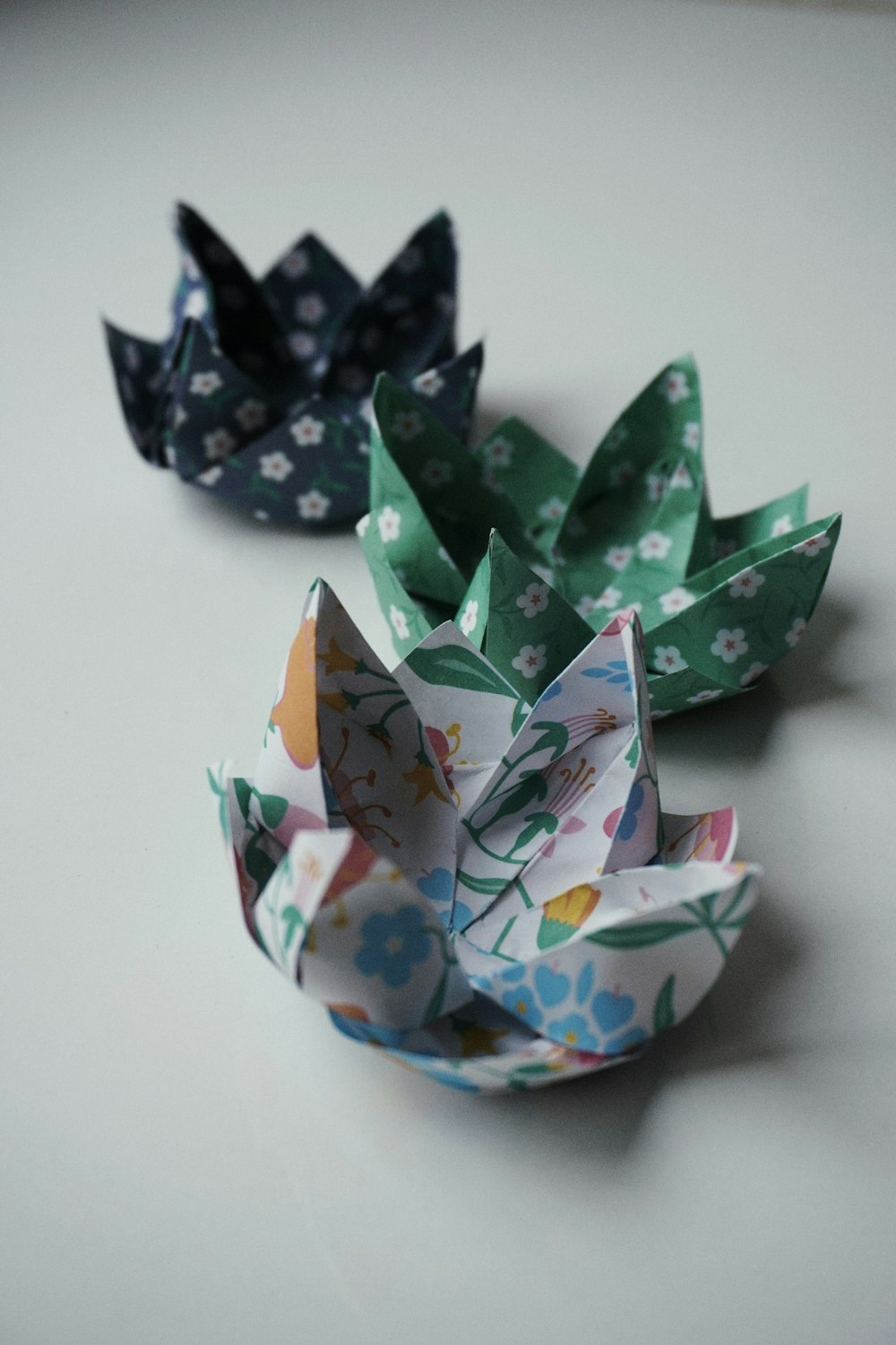 Drei Origami-Blumen auf einem Tisch sitzend