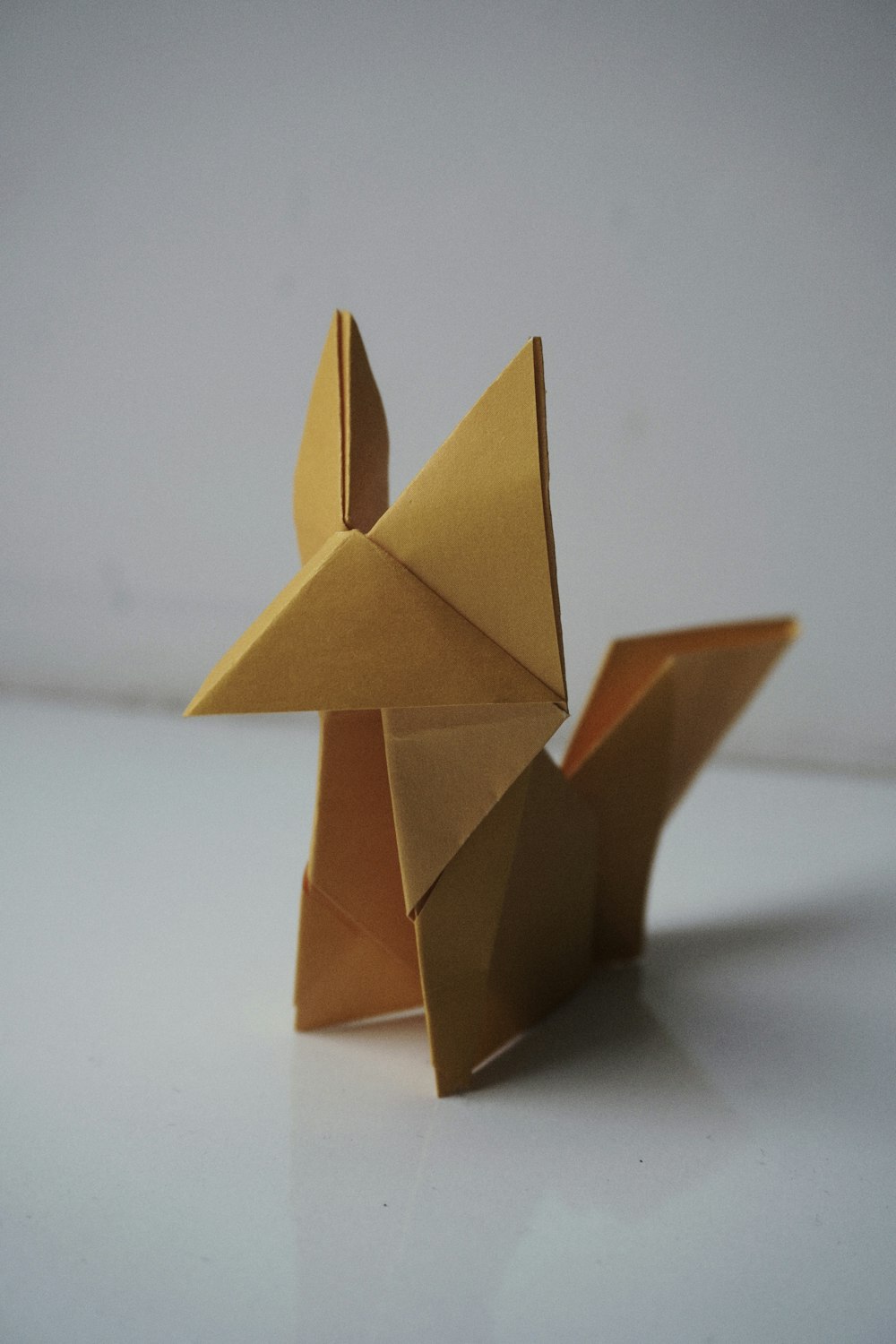 an origami animal made out of gold paper