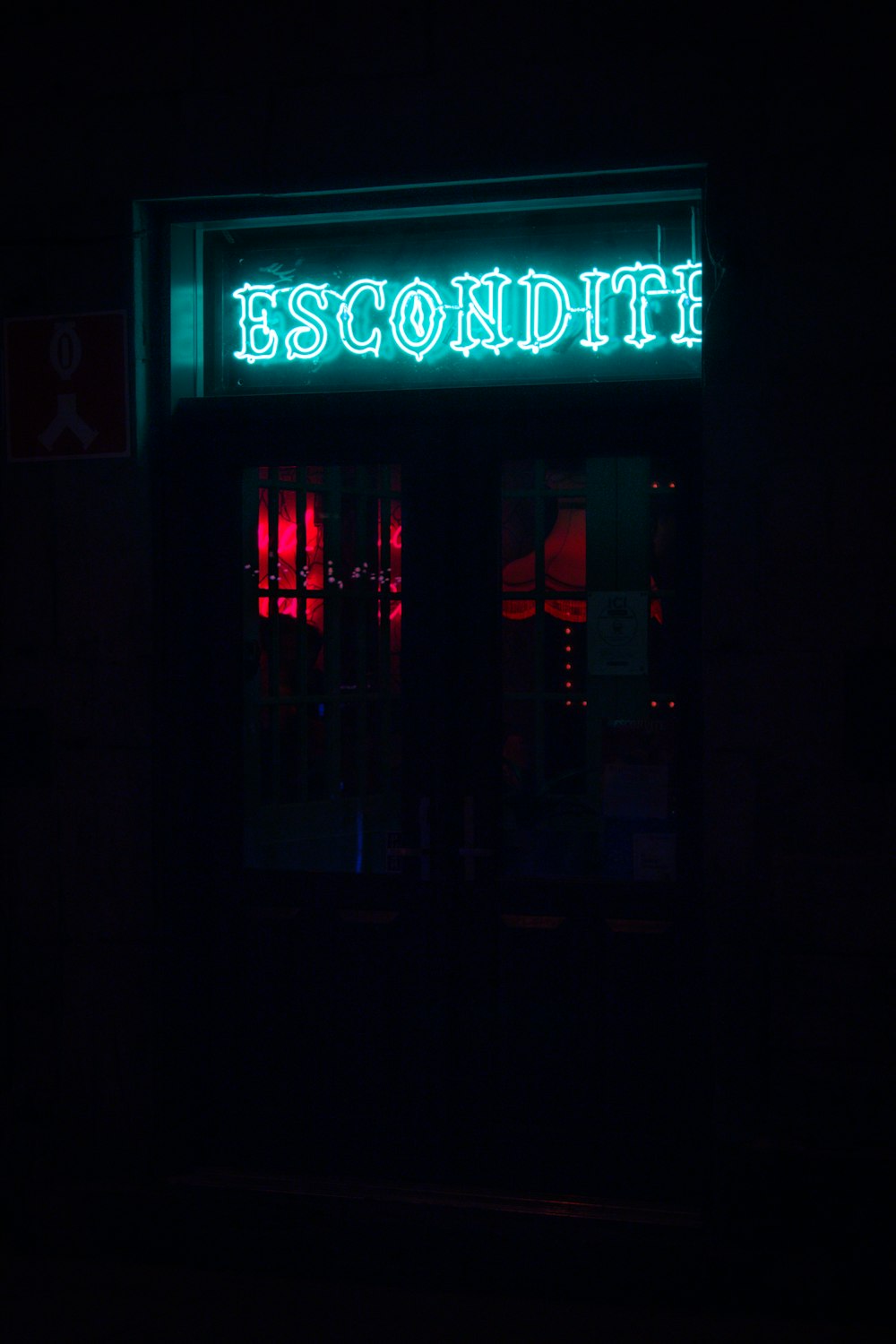 a neon sign that reads escondile lit up in the dark