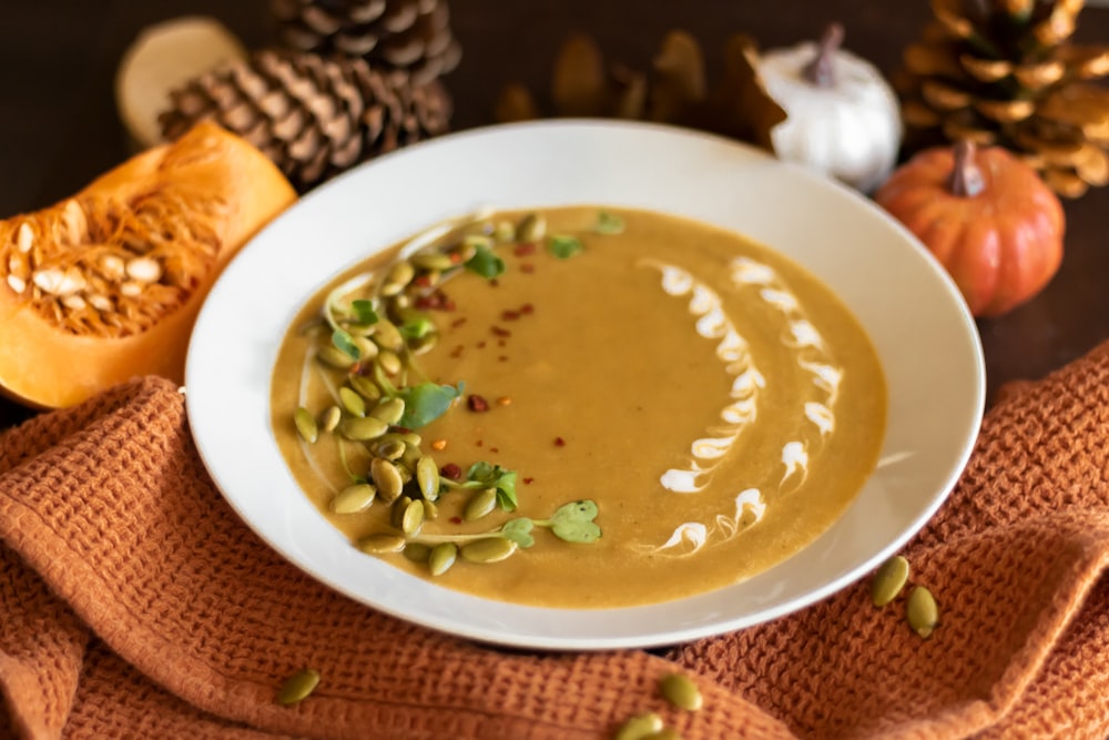 a bowl of soup with pumpkins and pumpkin seeds