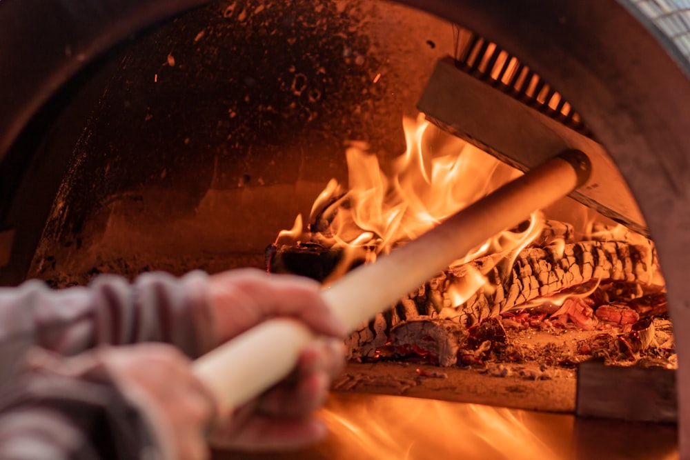 a close up of a person cooking food in a brick oven