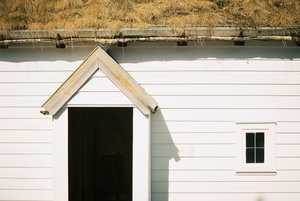 a white building with a grass roof on top of it