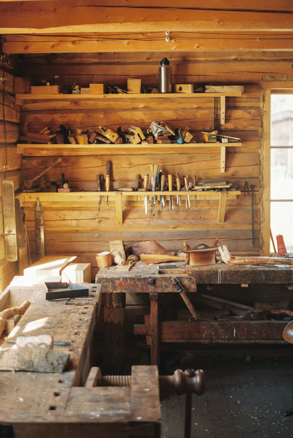 a workbench in a wooden cabin with lots of tools