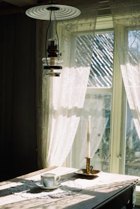 Intricate lace tablecloth spread over a rustic wooden table.
