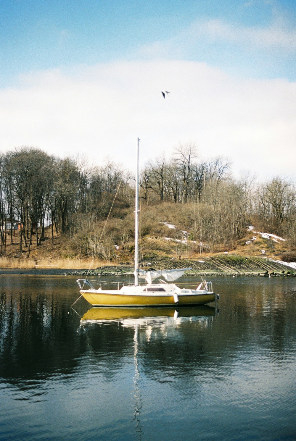 a yellow boat floating on top of a lake