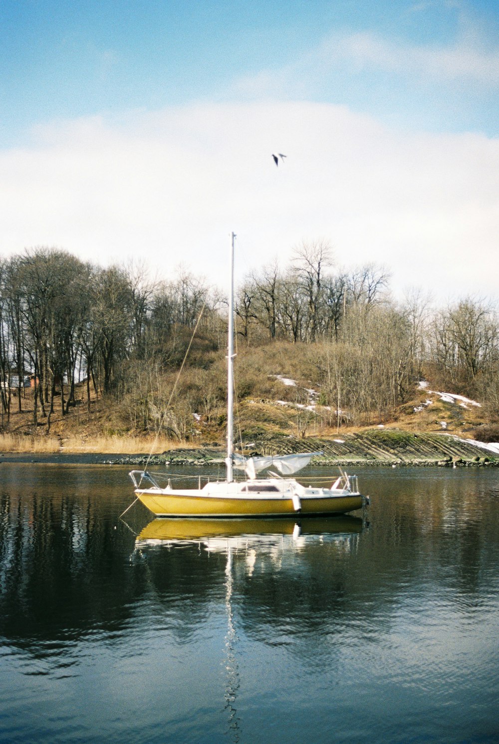 Una barca gialla che galleggia sulla cima di un lago