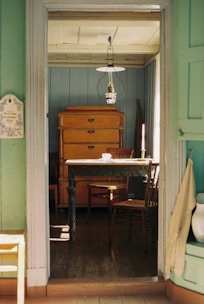 a room with a table, chairs, and a dresser