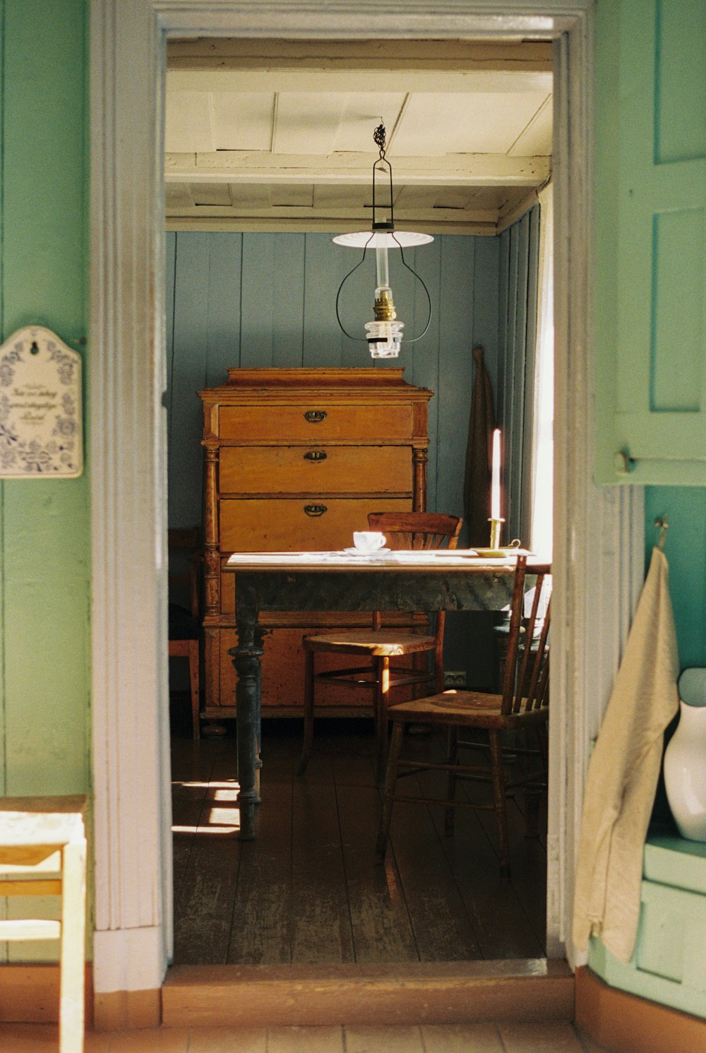 a room with a table, chairs, and a dresser