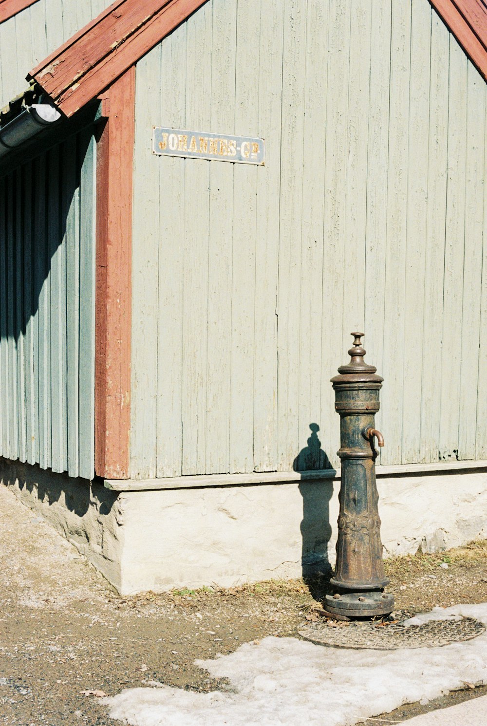 a rusted fire hydrant in front of a building