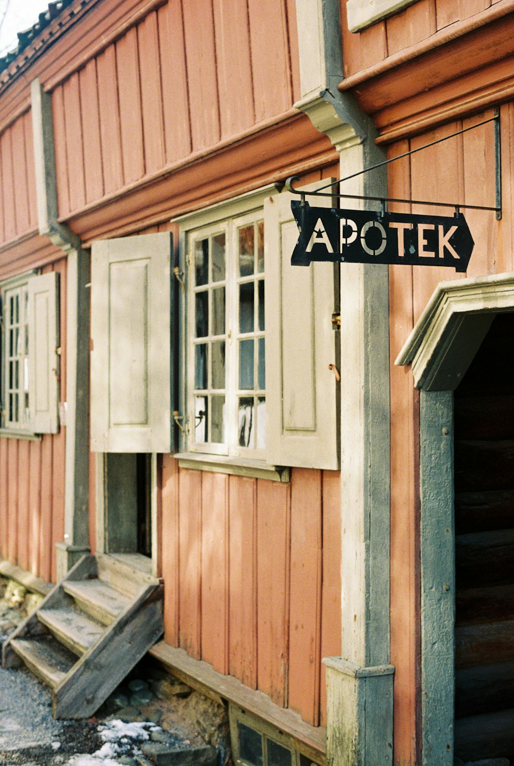 a wooden building with a street sign in front of it
